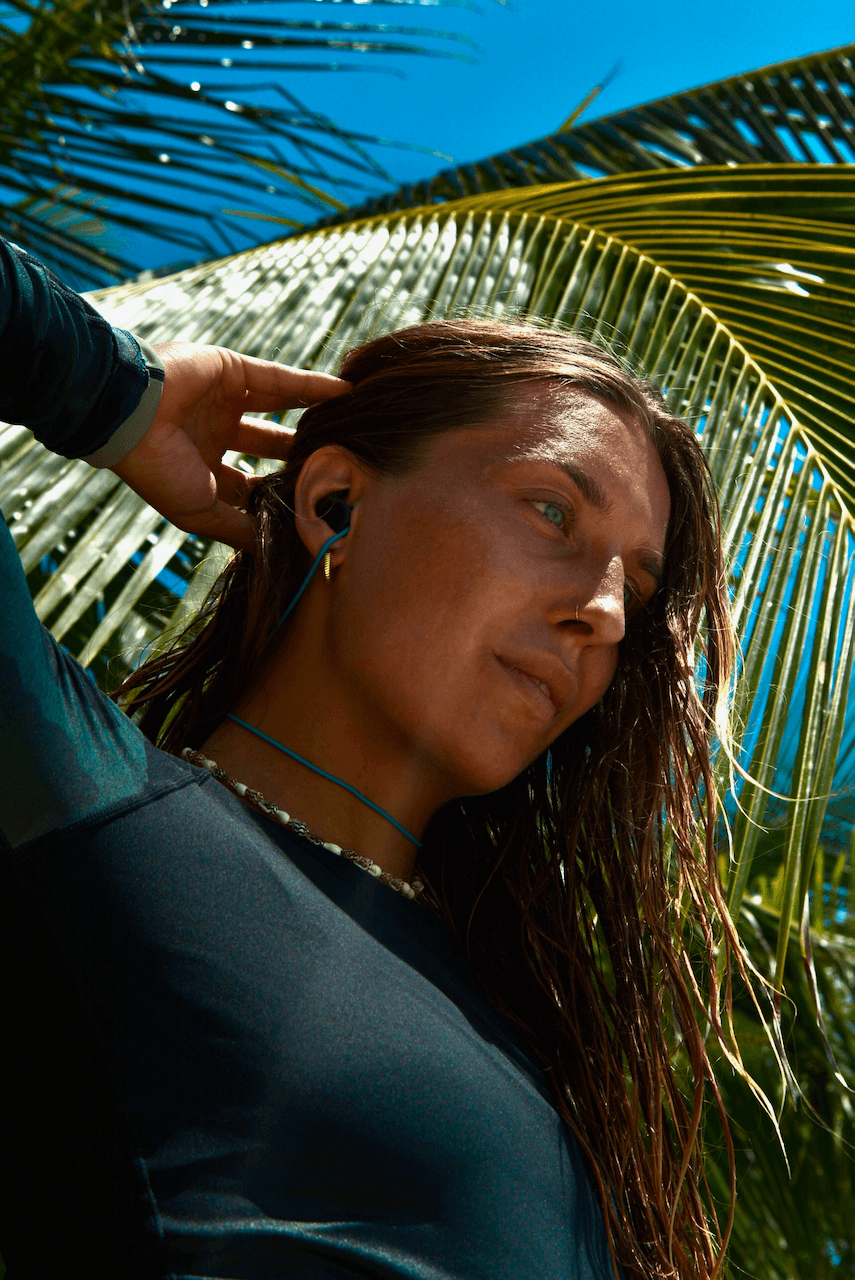 Julia wearing SEAR earplugs, surfing gear on